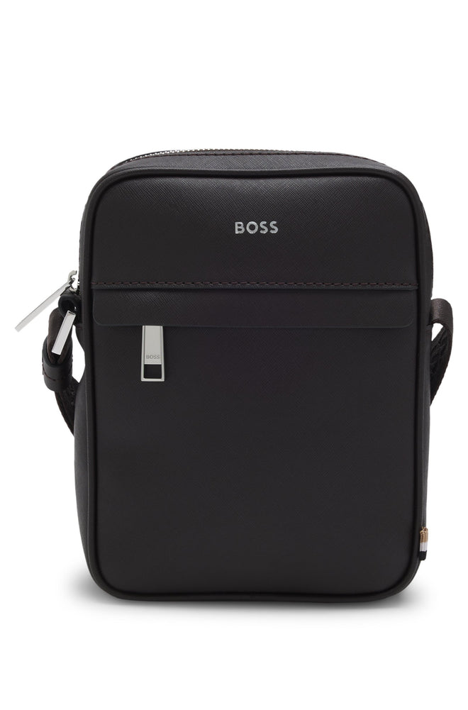 A sleek reporter bag by BOSS Menswear. Crafted from smooth faux leather, it features an adjustable shoulder strap and a front zipper pocket for convenience.